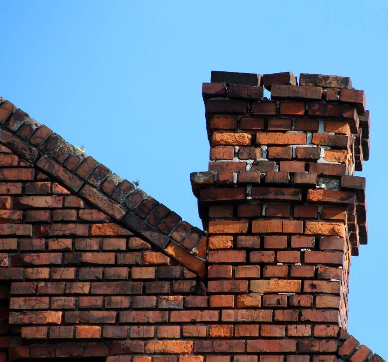 Damaged chimney on an Oceanside home showing cracks and missing mortar